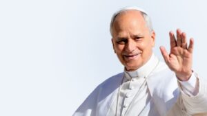 El papa León XIV saluda sonriente con la mano en alto